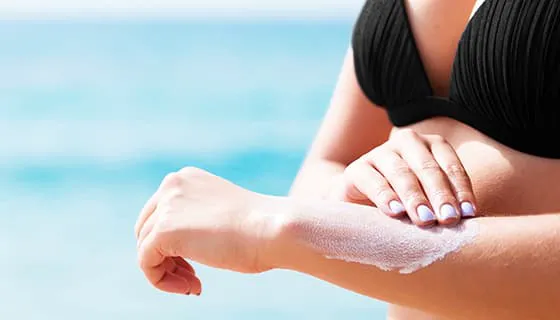 往手上涂防晒霜的女子图片素材(JPG)