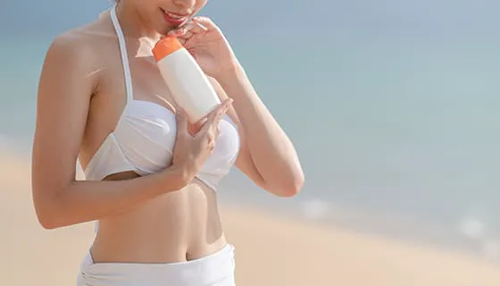 站在沙滩上涂防晒霜的女子图片素材(JPG)二