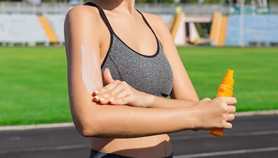 往手臂上涂防晒霜的女子图片素材(JPG)