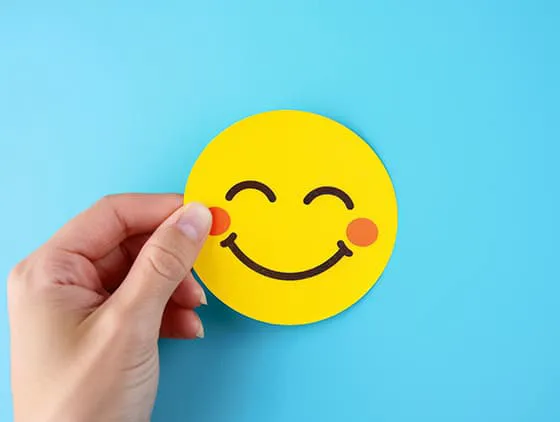 手拿一张微笑表情的黄色贴纸图片素材(JPG)